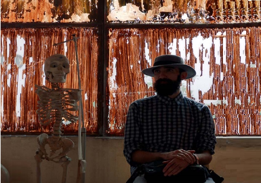 Frame. A man sitting next to a skeleton